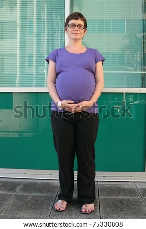 Pregnant woman with hospital admission tag outdoors in the grungy rbh grounds