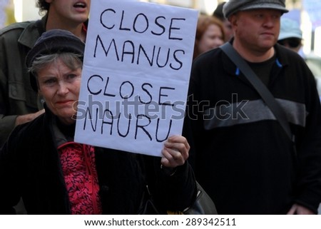 BRISBANE, AUSTRALIA - JUNE 20: Street marcher with sign calling for closure of Nauru and Manus island detention center during World Refugee Rally June 20, 2015 in Brisbane, Australia