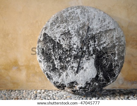 A mill stone used in wind and water mills for grinding wheat and grains