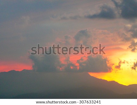 Red sunset with clouds and mountains skyline