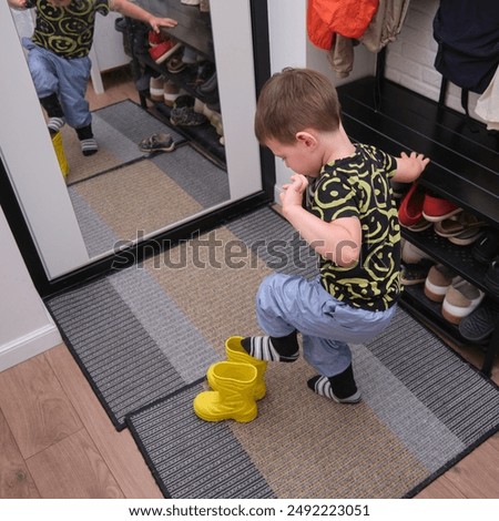 Similar – Image, Stock Photo Toddler standing with legs apart while holding onto to crib rails: nursery with peach, gray and white decor