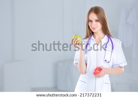 Doctor holding a green and red apple. Concept of healthy food.