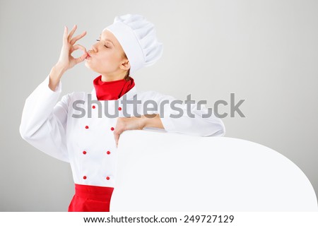 Chef woman - happy thumbs up. Smiling and cheerful female chef, cook or baker in uniform and hat isolated on white background.