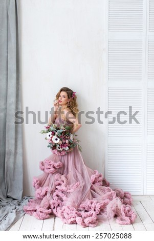 Fashion Beauty Model Girl with Flowers Hair. Bride. Perfect Creative Make up and Hair Style. Hairstyle. Bouquet of Beautiful Flowers.