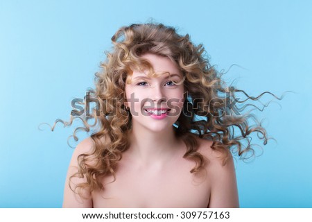 Hair in the wind. Portrait of beautiful smiling girl with luxuriant hair curling.