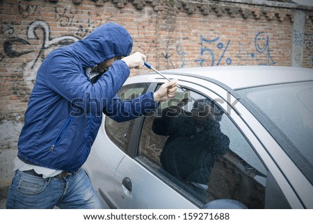 thief stealing automobile car at daylight street in city