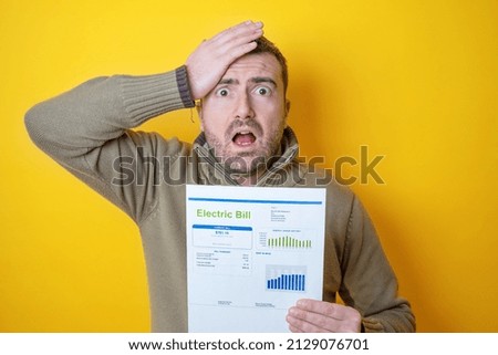 Shocked man reading some bills energy expenses isolated on yellow background Сток-фото © 