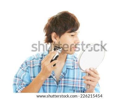 A man shaving with electric razor