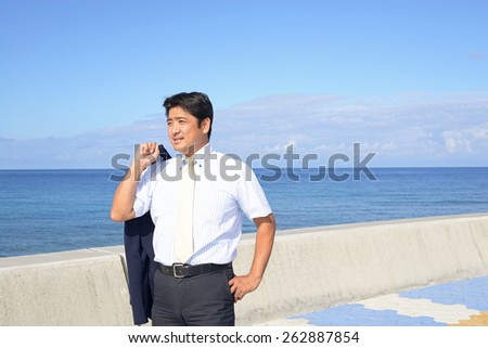 Asian businessman standing by the sea