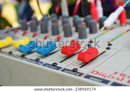 Control buttons for electronic sound. A sliders of a mixing console. Audio signals modifications to achieve the desired output. Applied in recording studios, broadcasting, TV and film production