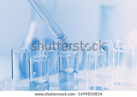 Laboratory glassware with a dropper dripping liquid into a test tube. scientific laboratory test tubes, laboratory equipment Stockfoto © 
