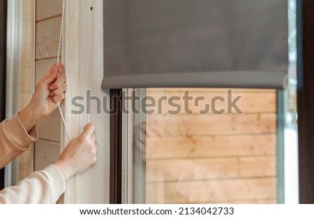 Fabric blinds window. Girl closes window with shutters Foto stock © 