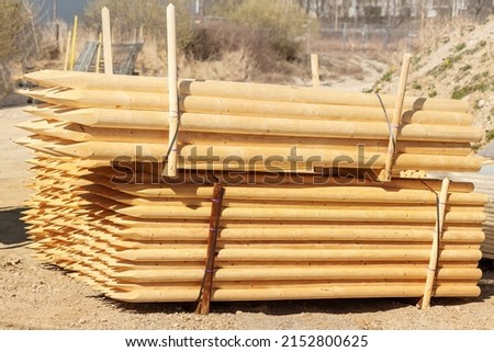 Log or Wooden Bar in pallet for  Wooden Construction Working. Large Rounded Wooden Bars cut ends to spikes, Logs for Supporting Large Trees. Round bars. Round Smooth Wooden Beams. Foto stock © 