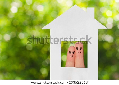 Finger art of a family. Family looking out of the window of the house out of paper.