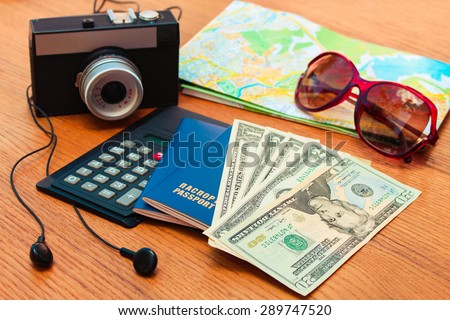 Travel set: passport, money, mobile phone, blank notebook, camera, road map, sunglasses, calculator, headphones. Summer accessories.