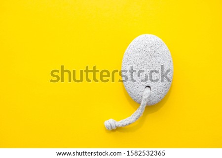 Natural pumice stone with white rope on yellow background. Pedicure and spa concept. Pumice stone for bathroom. Top view. Minimalist Style. Copy, empty space for text ストックフォト © 