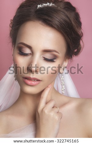 Portrait of a beautiful woman in a wedding dress in the image of the bride. Picture taken in the studio. Portrait of beautiful bride. Wedding dress. Wedding decoration