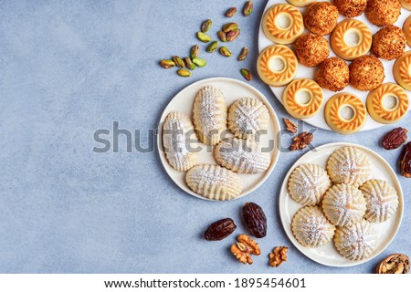  Arabic sweets. Traditional eid semolina maamoul or mamoul cookies with dates , walnuts and pistachio nuts  . Top view, copy space                          