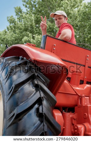 funny picture of a farmer who drives a tractor and shows peace sign