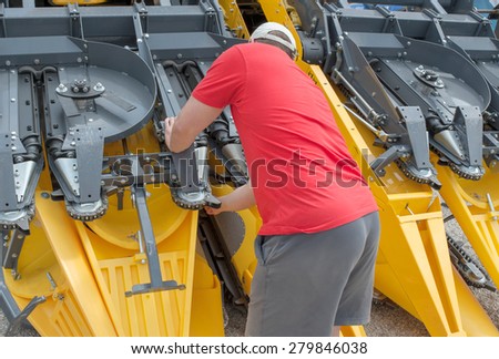 young  farmer do some repairs on harvester