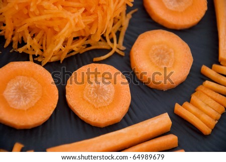 Slices of fresh organic carrot on black plate