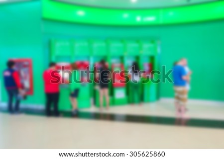 Blurred image of people take money from ATM machine in Department store or bank.