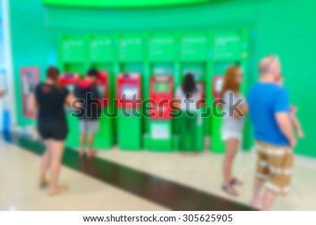 Blurred image of people take money from ATM machine in Department store or bank.