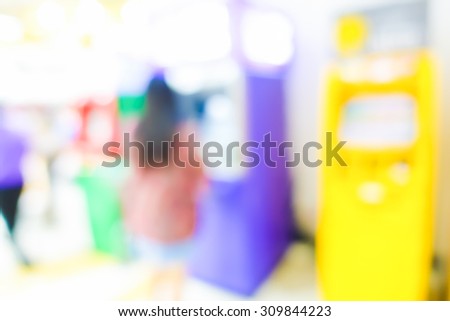 Blurred image of woman use ATM machine in bank to take money or do something about financial.