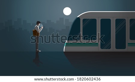 Lonely office man first jobber use smart phone waiting in public transportation station for last train at night alone in the dark and full moon light. City lifestyle of work late overtime and overwork