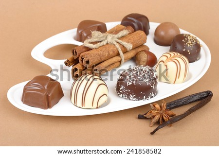 Chocolates and nuts on a palette on a white background.