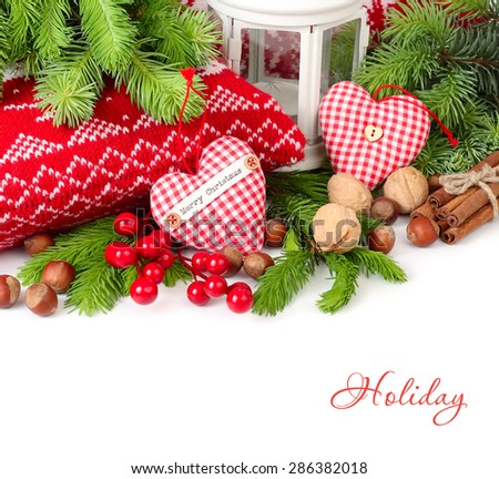 Textile hearts, nuts and cinnamon near knitted pillows and branches of a Christmas tree on a white background. Christmas background.