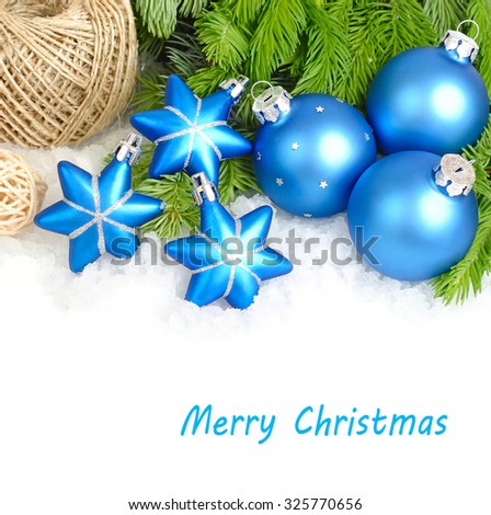 Blue Christmas balls and stars on fluffy branches of a Christmas tree on a white background. A Christmas background with a place for the text.