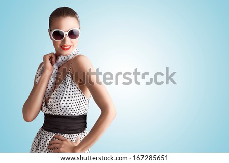 Cool photo of a pin-up girl in spotted vintage dress; sunglasses and scarf.