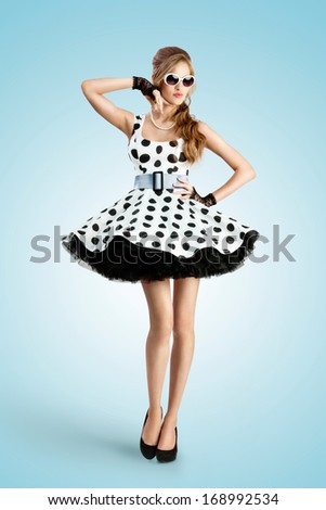 A vintage photo of a beautiful pin-up girl wearing a retro polka-dot dress and sunglasses.