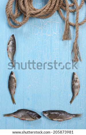 frame from dried fish and twisted rope on the background of painted wooden tablets