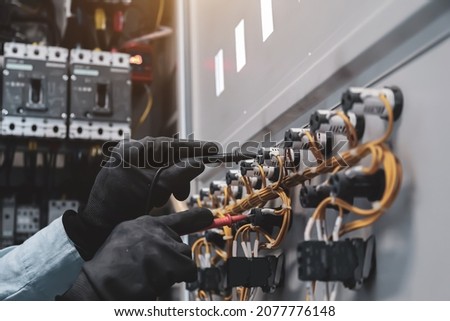 Electricity and electrical maintenance service, Close-up circuit breaker has engineer using measuring equipment checking electric volt at terminal block and cable wiring main power distribution board. Photo stock © 