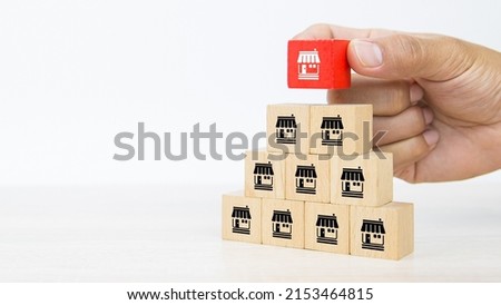 Franchise, Close-up hand choose cube wooden toy block stack with franchises business store icon for franchising business marketing plan to growth and branch expansion and banking loan. Сток-фото © 