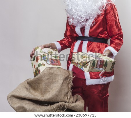 Santa Claus taking out presents from a jute sack