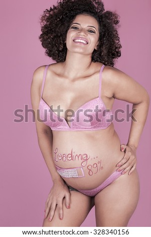 Beautiful pregnant woman portrait with painted belly posing