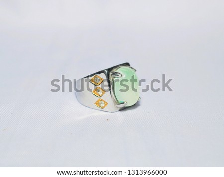 green gemstone with titanium ring