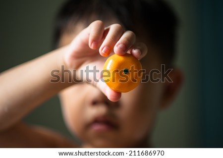 Children\'s hand holding tangerine