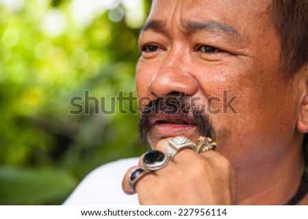Casual middle aged man with hand near the face with a concerned look