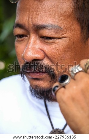 Casual middle aged man with hand near the face with a concerned look