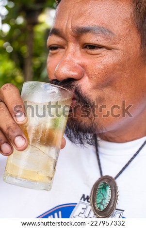 Elderly man holding a beer belly