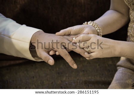 Groom wearing the Diamond ring to bride hand in Wedding ceremony