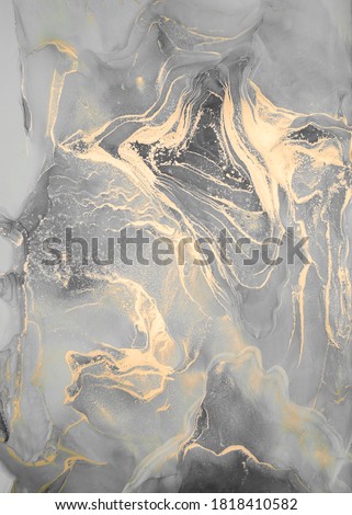 High resolution. Luxury abstract fluid art painting in alcohol ink technique, mixture of black, gray and gold paints.  Imitation of marble stone cut, glowing golden veins. Tender and dreamy design. 