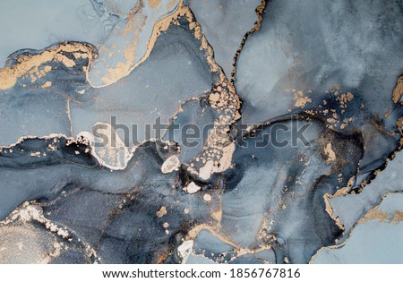 Luxury abstract fluid art painting in alcohol ink technique, mixture of black, gray and gold paints.  Imitation of marble stone cut, glowing golden veins. Tender and dreamy design. 