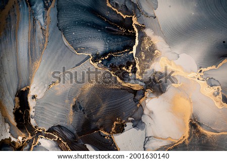 High resolution. Luxury abstract fluid art painting in alcohol ink technique, mixture of dark blue, gray and gold paints. Imitation of marble stone cut, glowing golden veins. Tender and dreamy design.