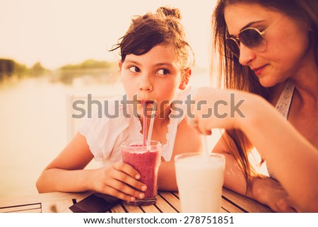 Worried and tired mother drinking juice with her daughter at cafe. Leave your work problems at work, don\'t affect your child with them