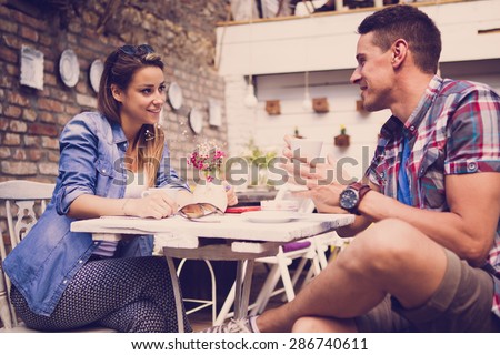 Young happy couple sitting at cafe